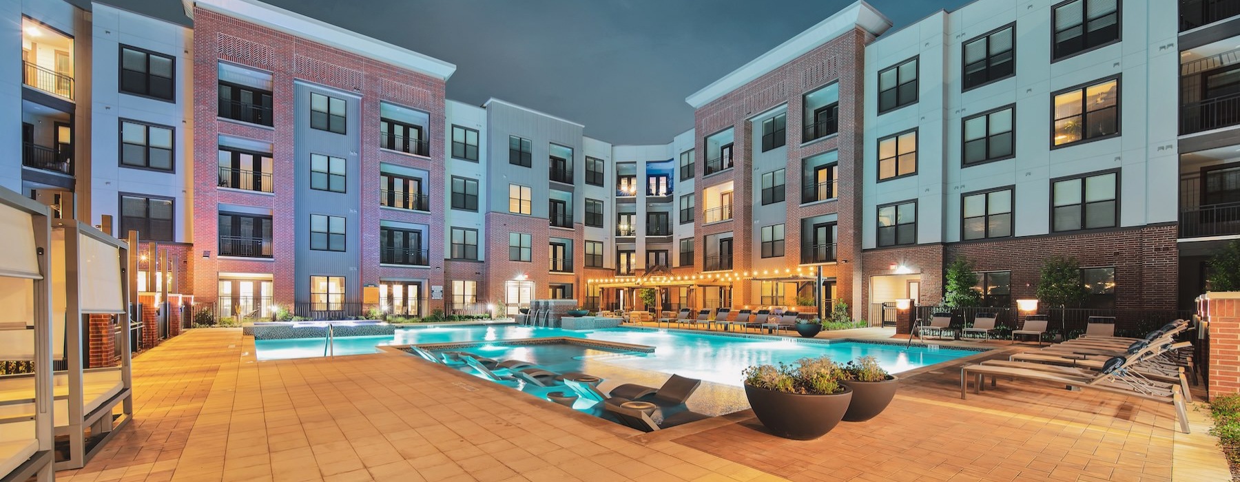 a pool in a courtyard with a large building in the background