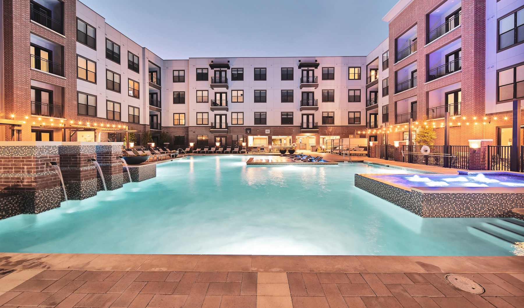 a pool in a courtyard with a large building in the background